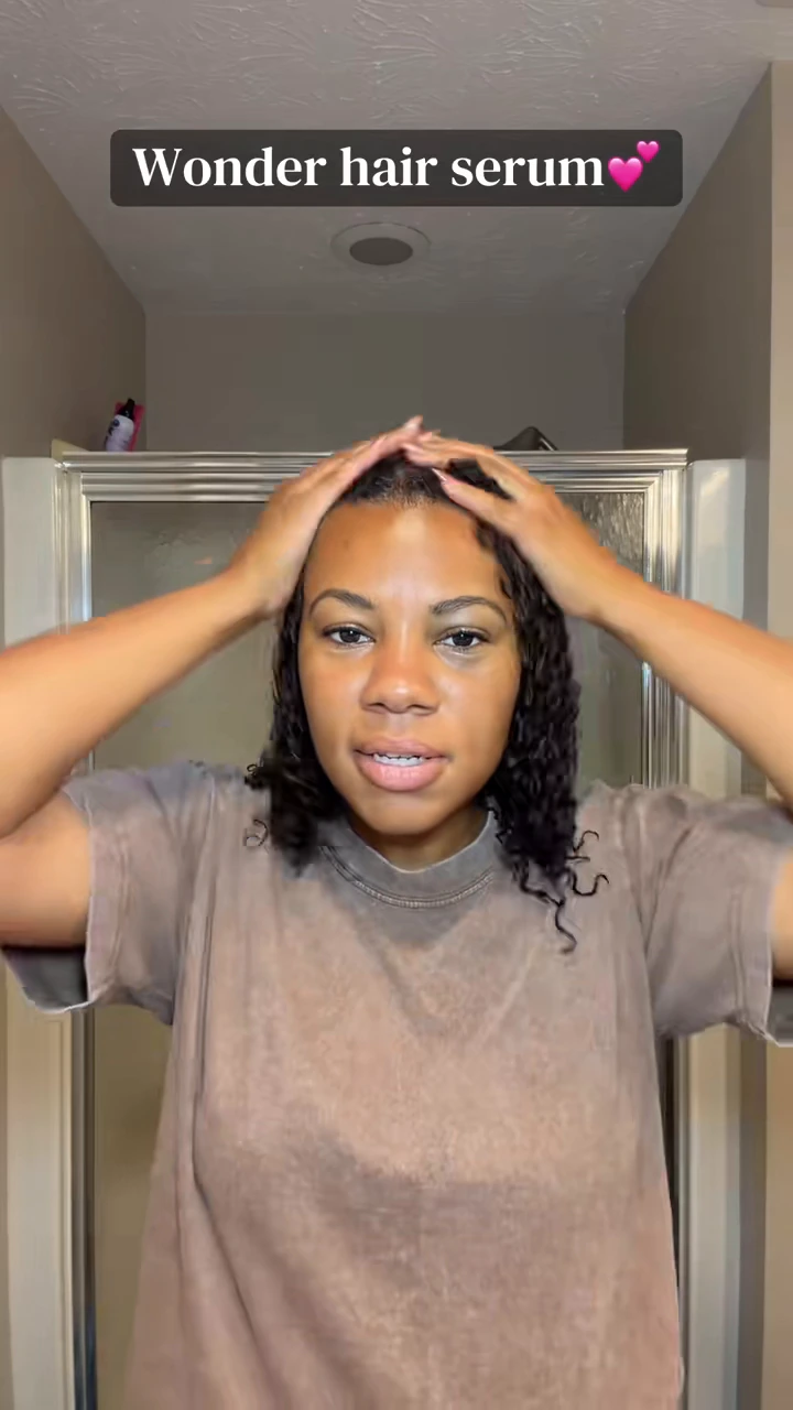 Denita massaging oil through her curls in her original routine